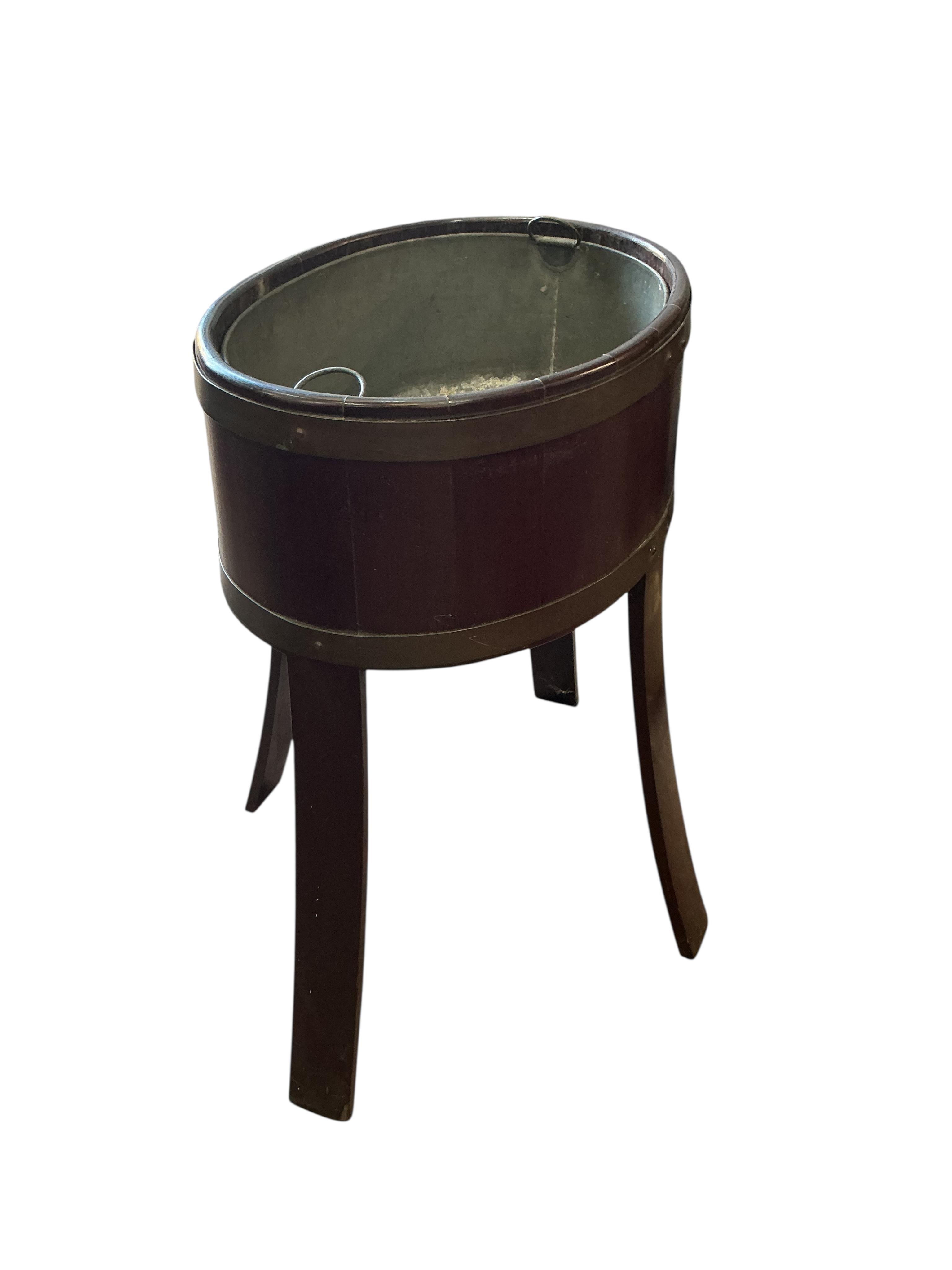 A brass bound oval mahogany jardiniere with liner, width 48cm, depth 34cm, height 62cm